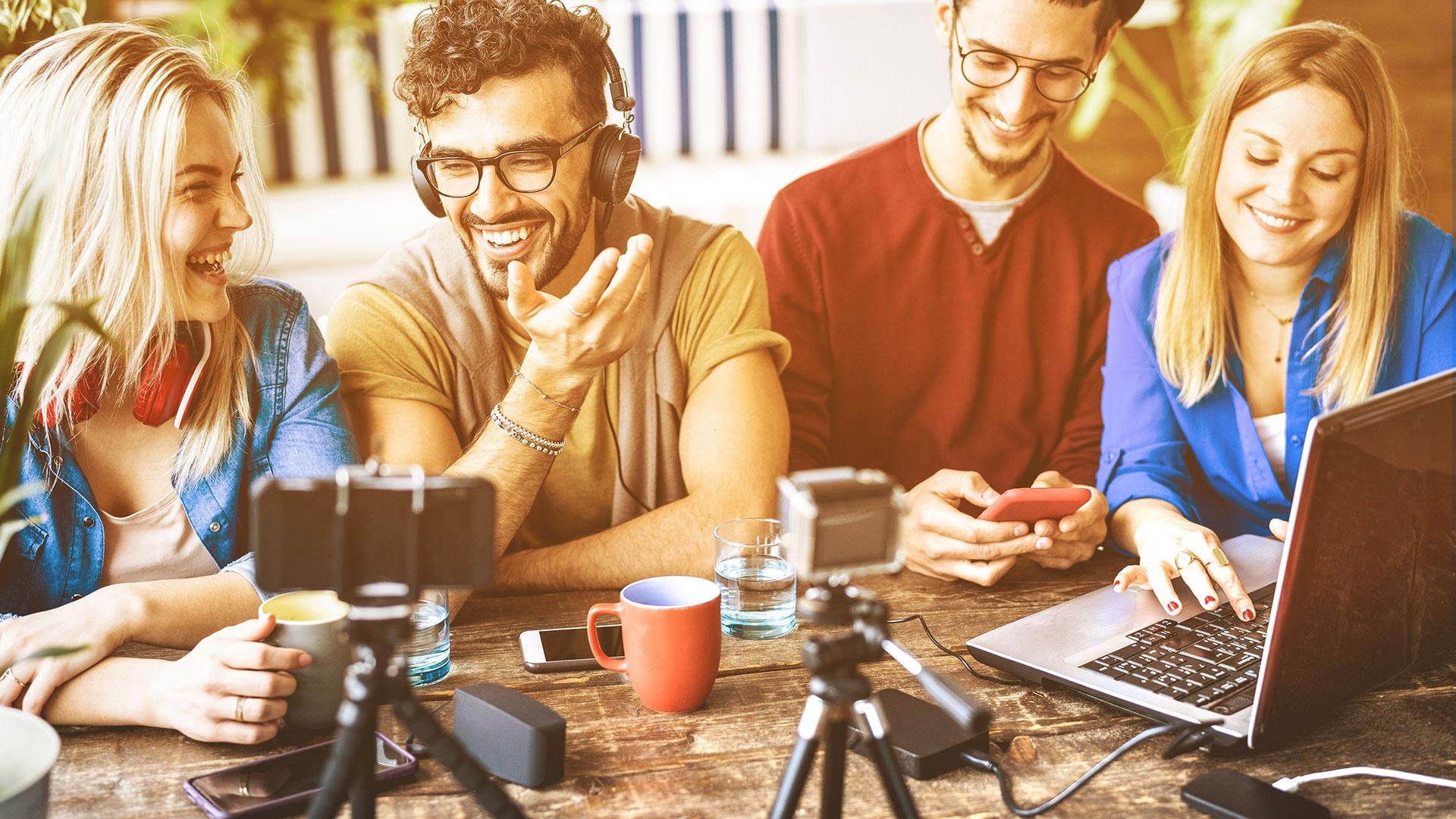 Junge Content-Creator produzieren digitale Inhalte mit Laptop und Kamera – Teamarbeit im modernen Online-Marketing.